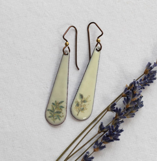 Teardrop-shaped earrings with floral designs on a white background with lavender.
