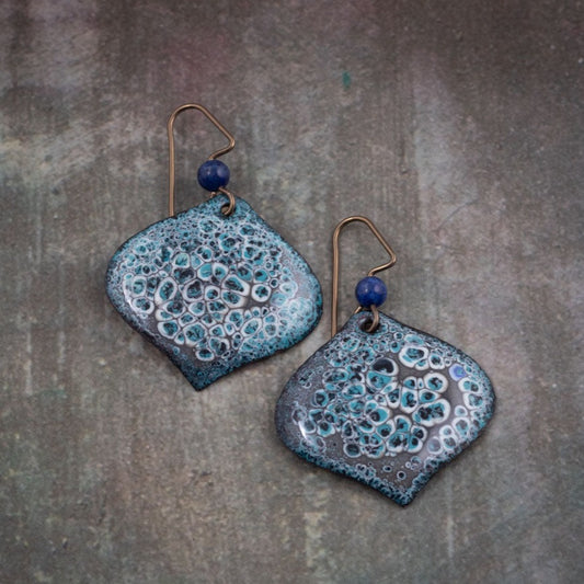Dark teal and black enamel earrings with textured bubbling detail, handcrafted on copper with niobium ear wires and deep blue accent beads.
