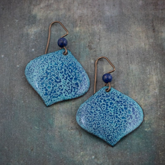 Handcrafted ocean tide blue enamel earrings featuring a delicate speckled pattern and accented with lapis lazuli beads on niobium ear wires.