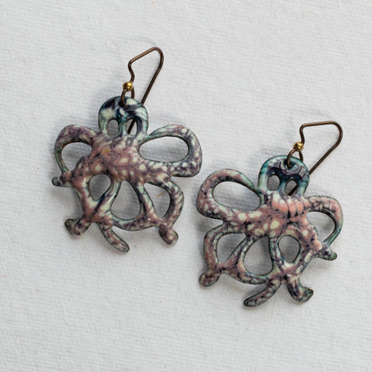 Pair of octopus-shaped earrings on a light gray background