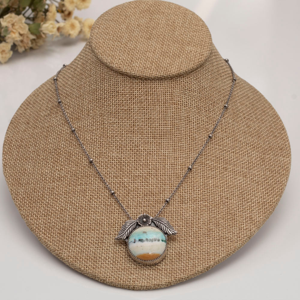 Handmade sterling silver necklace with opalized petrified wood and floral accents.