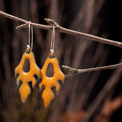 Handmade enamel copper earrings in golden yellow with organic frond-like design and sterling silver ear wires, bold botanical statement jewelry.