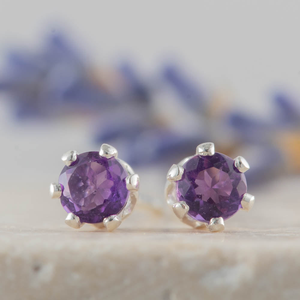 Amethyst gemstone stud earrings on a neutral background