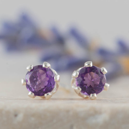 Amethyst gemstone stud earrings on a neutral background