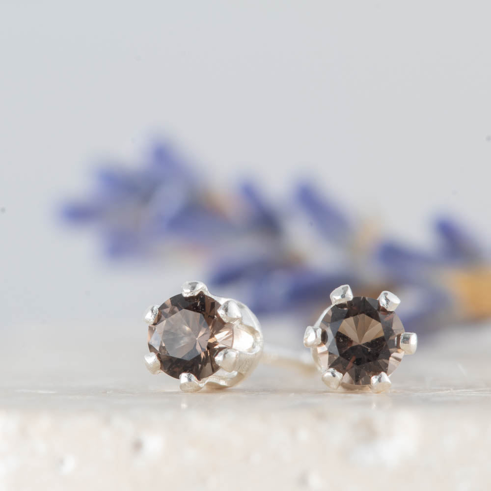 Pair of silver stud and smoky quartz gemstone earrings on a light background