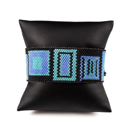 Handwoven beaded cuff bracelet with colorful geometric pattern on black background, fits 7 inch wrist