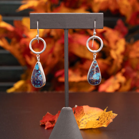 Purple Mohave turquoise sterling silver earrings with teardrop stones, bronze matrix, fine silver settings, smooth silver hoops, and sterling silver ear wires, handmade by Divella Designs.