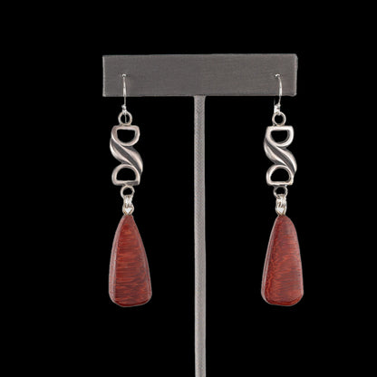 Handcrafted dangle earrings with deep red Bibingka wood teardrops and sculptural sterling silver links, modern artisan design displayed on black background – by Divella Designs