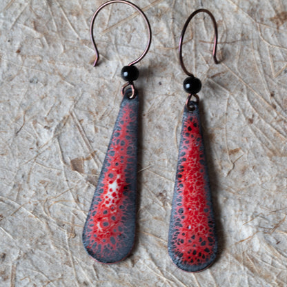 Red enamel teardrop earrings with dark speckled lace-like detail, black onyx beads, and niobium ear wires.