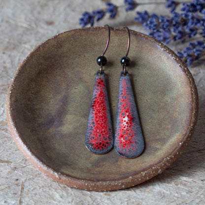 Red enamel teardrop earrings with dark speckled lace-like detail, black onyx beads, and niobium ear wires.