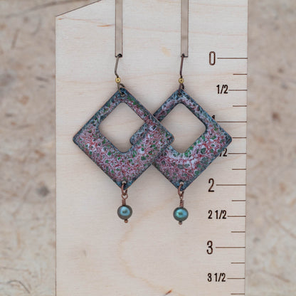 Red and green enamel openwork earrings shown for scale with airy center openings and freshwater pearl drops.