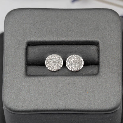 Silver round earrings in a gray jewelry box