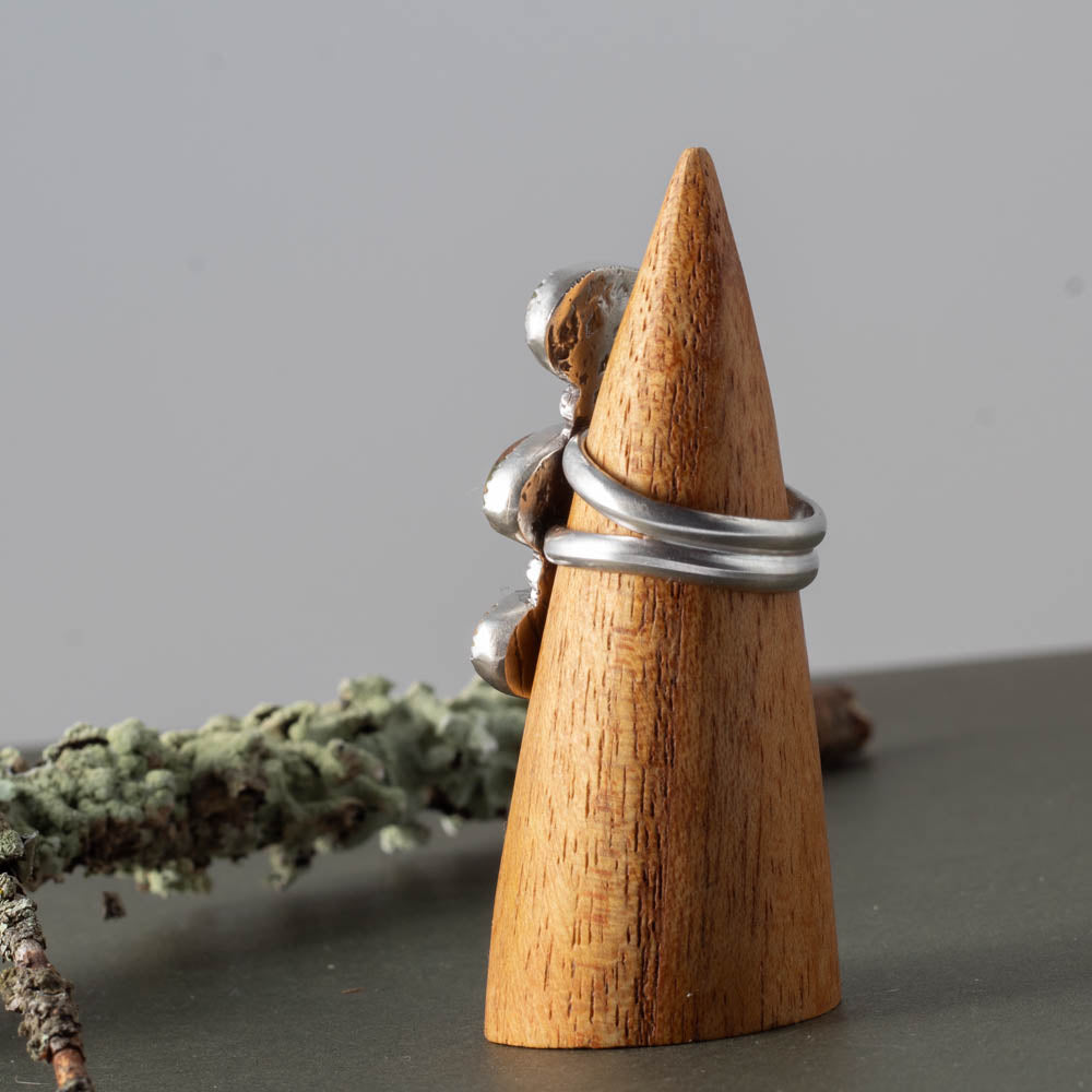 Wooden cone with silver rings on a gray surface