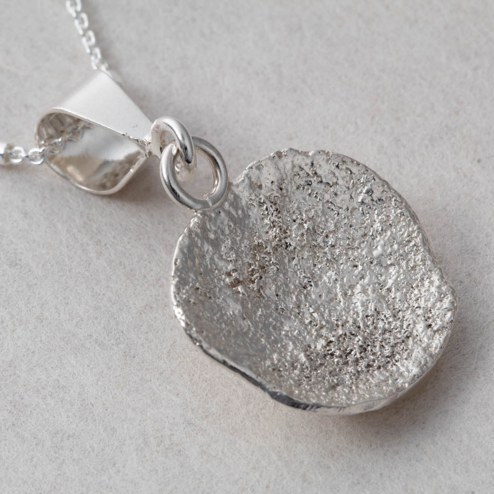 Fused silver dust necklace with organic lichen-like texture and sterling silver setting, handmade in Vermont by Divella Designs.