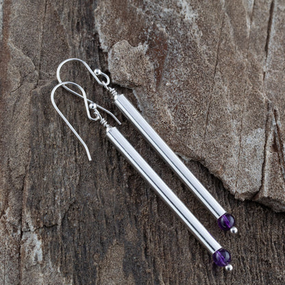 Close up of handmade sterling silver drop earrings with long vertical bars and faceted amethyst gemstones, featuring minimalist modern design and elegant artisan style.
