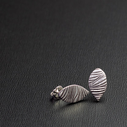SEO Alt Text:
Handcrafted sterling silver leaf-shaped stud earrings with textured woodgrain pattern, minimalist nature-inspired jewelry for everyday wear.