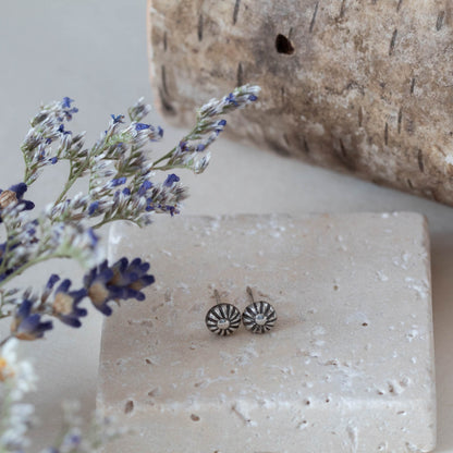 Tiny handmade sterling silver stud earrings with oxidized floral sunburst design, featuring 5mm round shape and minimalist vintage-inspired style.