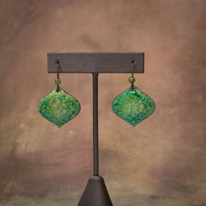 Artisan enamel earrings in soft green and yellow tones with lichen-like texture, handmade on copper with niobium ear wires.