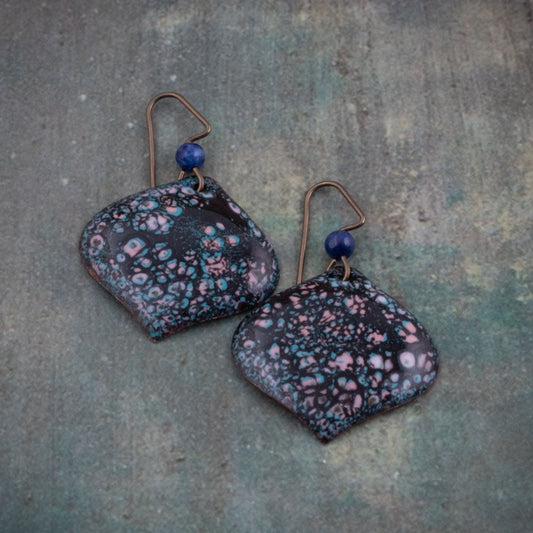 Deep blue enamel earrings with speckled pink and teal lichen-like texture, handcrafted on copper with niobium ear wires and deep blue accent beads.