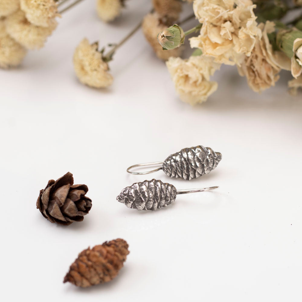 Sterling silver pine cone dangle earrings with nature-inspired design, handmade woodland jewelry.