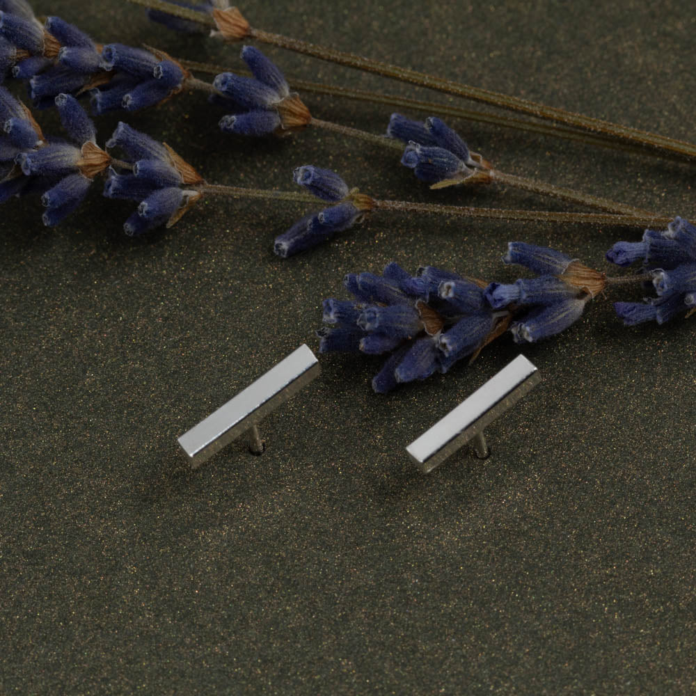 Modern solid sterling silver bar studs on dark background