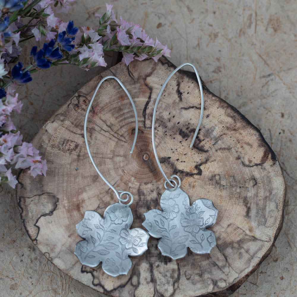 Sterling silver botanical impression earrings by Divella Designs, handmade in Vermont with floral textured pattern and satin finish, 2 1/2" drop on curved ear wires