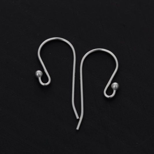 Two silver earring hooks on a black background