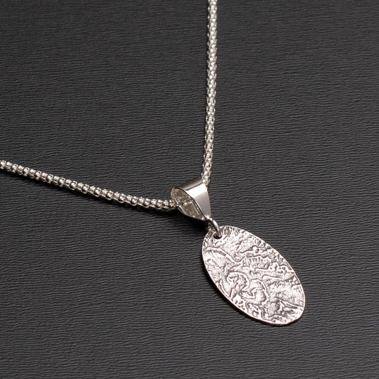 Sterling silver oval pendant necklace with textured landscape design on 18-inch chain.