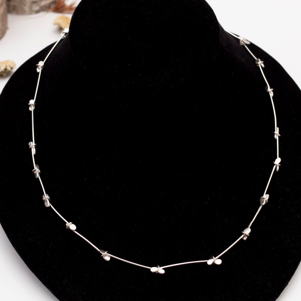Minimalist sterling silver necklace with handcrafted paddle links and blossom-like accents – modern artisan jewelry