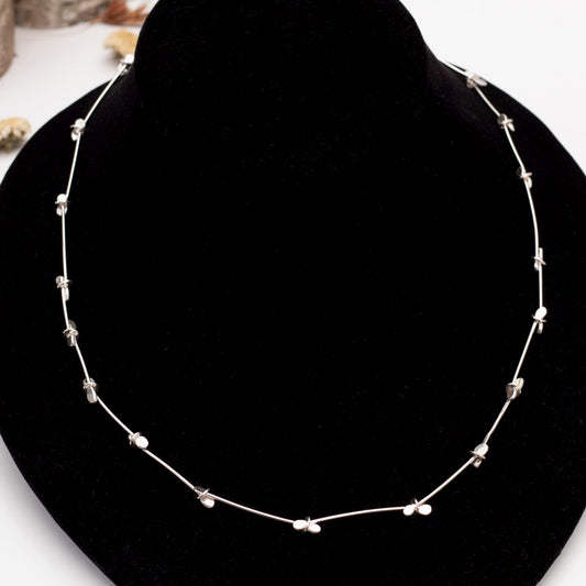 Minimalist sterling silver necklace with handcrafted paddle links and blossom-like accents – modern artisan jewelry