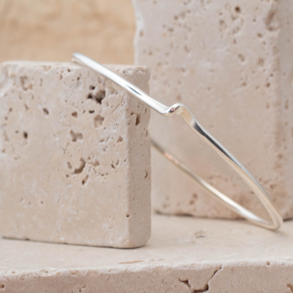Silver bracelet on a textured stone surface