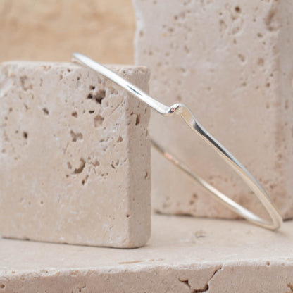 Silver bracelet on a textured stone surface