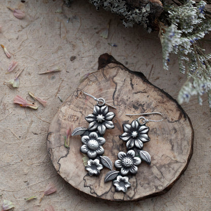 Sterling silver wildflower garden earrings with layered botanical details, soft patina, and handmade finish, crafted in Vermont by Divella Designs.