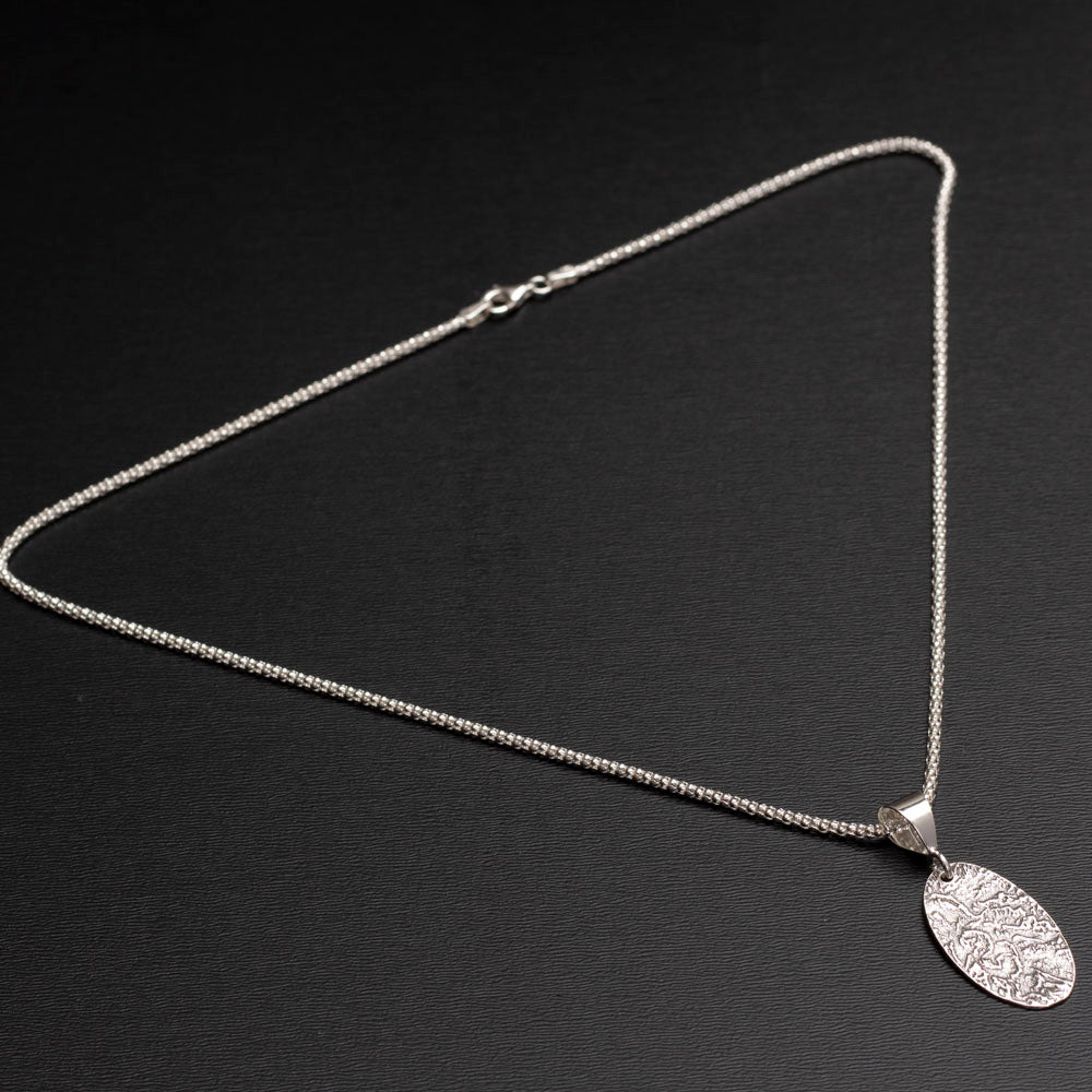 Sterling silver oval pendant necklace with textured landscape design on 18-inch chain.