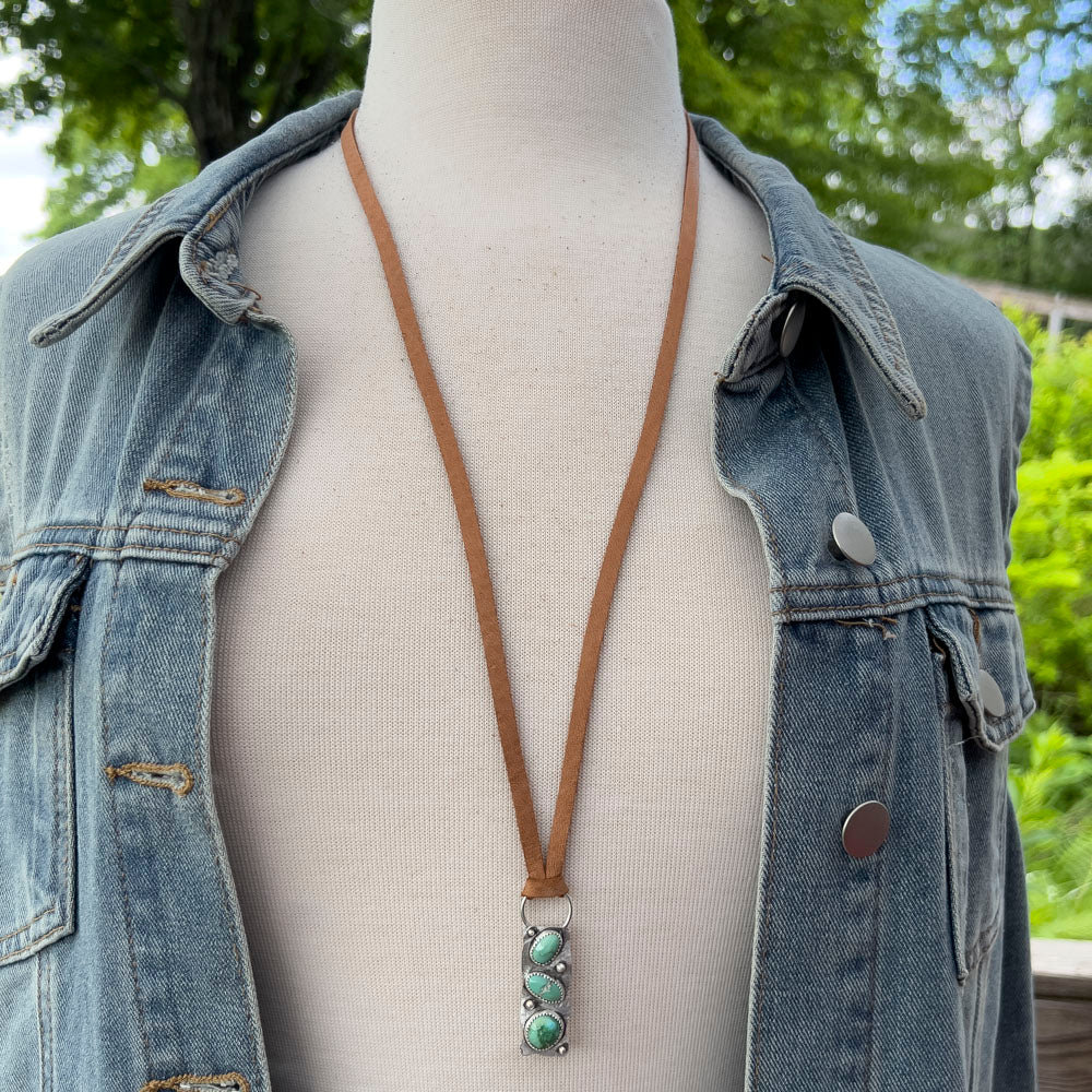 Mannequin wearing a denim jacket with a brown leather necklace featuring Verde Valley turquoise stones.
