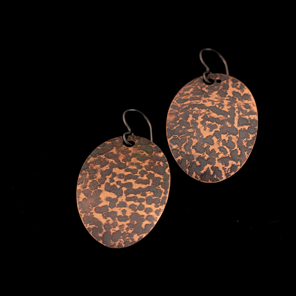 Textured copper oval earrings with oxidized patina, polished copper highlights, and 1 5/16 inch length, handmade by Divella Designs in Vermont.