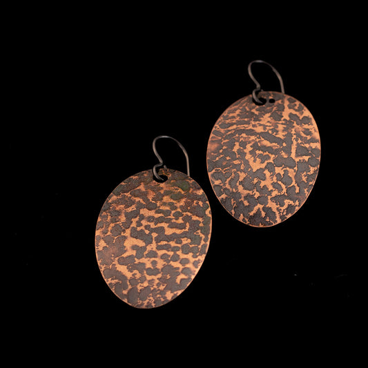Textured copper oval earrings with oxidized patina, polished copper highlights, and 1 5/16 inch length, handmade by Divella Designs in Vermont.