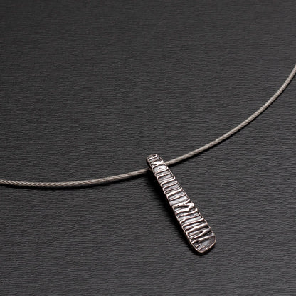Sterling silver pendant with ripple texture on tapered form, reminiscent of water movement