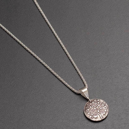 Sterling silver reversible pendant necklace with paw print and tree of life designs on 18-inch chain.