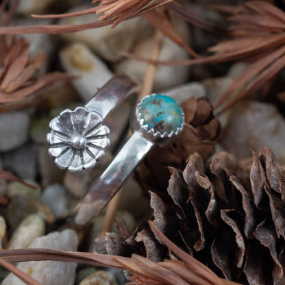 Nature-inspired silver wrap ring with turquoise gemstone styled with pinecone and dried lavender
