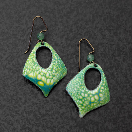 Handmade green enamel earrings with a botanical texture, diamond cutout shape, and niobium ear wires with green stone accents, inspired by forest foliage and spring growth.