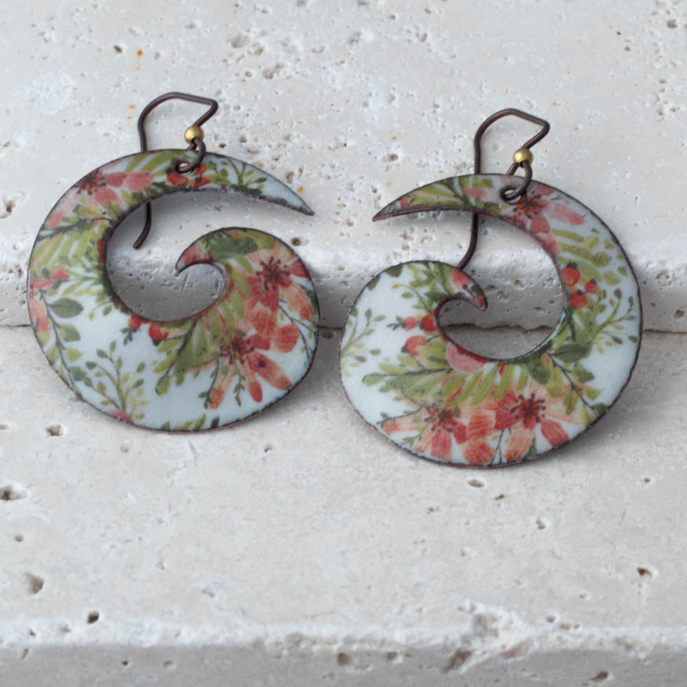 Pair of floral-patterned earrings on a textured white surface
