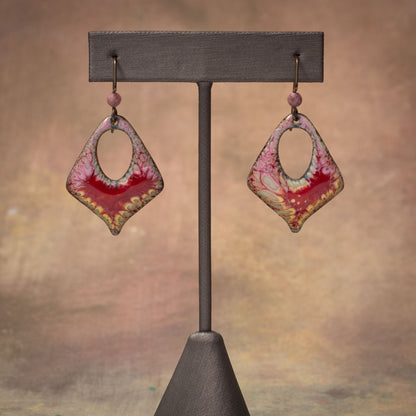 Handmade enamel earrings in pink and crimson with organic lace-like pattern, crafted on copper with niobium ear wires.