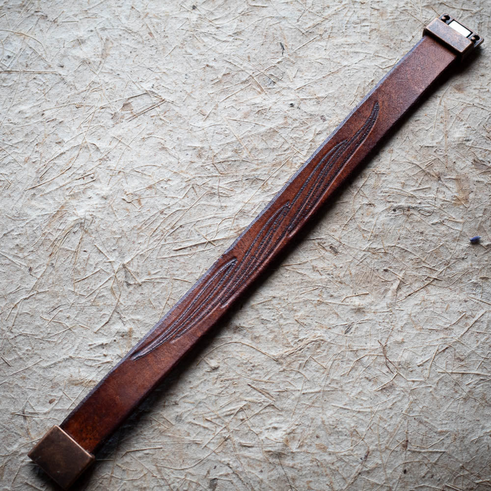 Brown leather strap on a textured beige surface