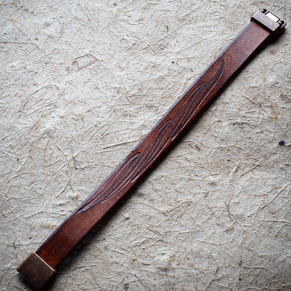 Brown leather strap on a textured beige surface