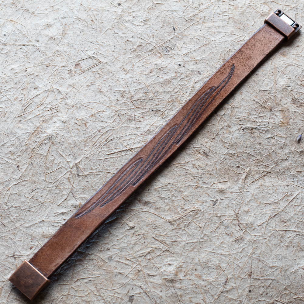 Brown leather cuff on a textured beige surface