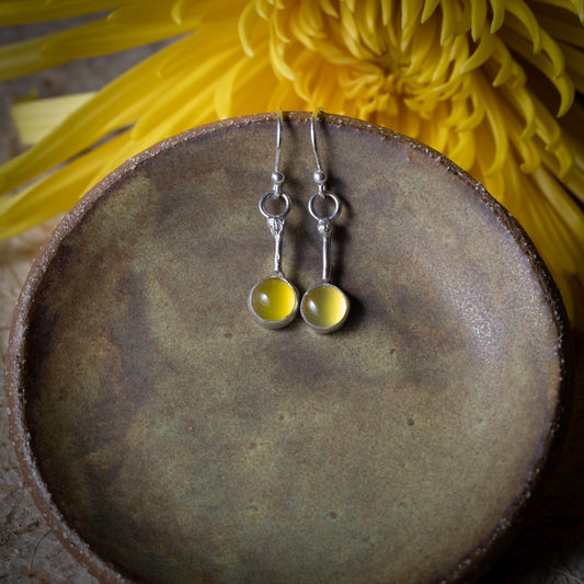 Yellow chalcedony Lemon Drop earrings with 6mm round stones and slender sterling silver stems displayed on a ceramic dish