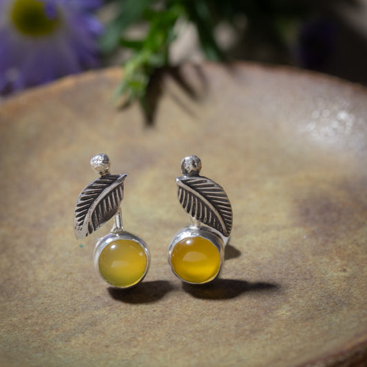 Yellow chalcedony Lemon Drop stud earrings with textured sterling silver leaves and rounded bezels standing on a ceramic dish
