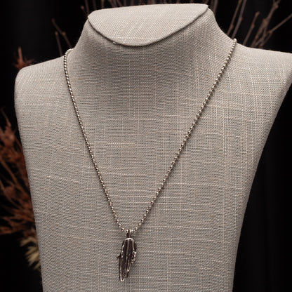 abstract sterling silver necklace on  a neutral linen bust.