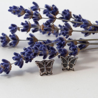 Sterling silver butterfly stud earrings displayed on a white background with lavender sprigs.